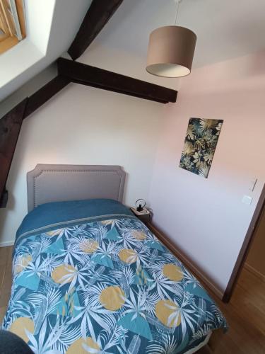 1 dormitorio con 1 cama con colcha azul y amarilla en Maison chaleureuse avec netflix et ps5 en Valenciennes