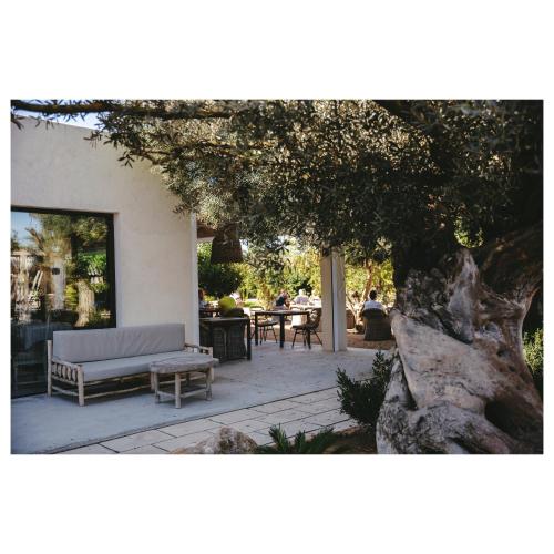 a patio with a couch and a table and a tree at Can Arabí - Adults Only in Ibiza Town