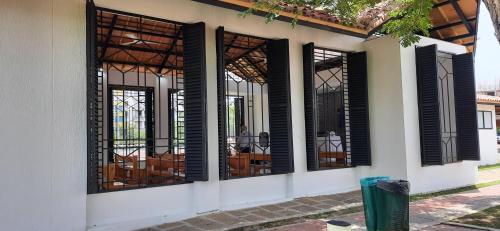 a group of windows with black shutters on a building at Peñazul La Aldea Condominio en Ricaurte Campestre - Apartamento con vista a piscinas in Ricaurte