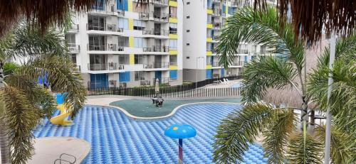 a view of a swimming pool with palm trees at Peñazul La Aldea Condominio en Ricaurte Campestre - Apartamento con vista a piscinas in Ricaurte