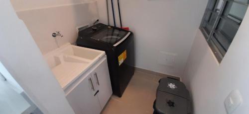 a small bathroom with a trash can and a black bag at Peñazul La Aldea Condominio en Ricaurte Campestre - Apartamento con vista a piscinas in Ricaurte