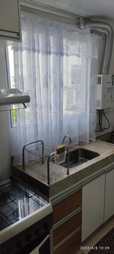 a kitchen counter with a sink and a window at Apto térreo com área privativa ! in Rio das Ostras