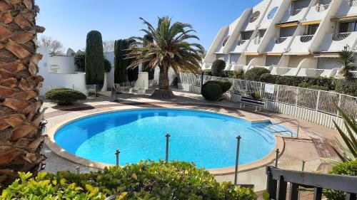 une grande piscine devant un immeuble dans l'établissement Ancre bleue***, 1ère ligne plage, piscine, Clim., à La Grande Motte