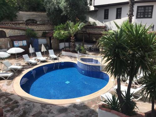 a large swimming pool in a courtyard with chairs at Villa Citronella Boutique Hotel in Antalya