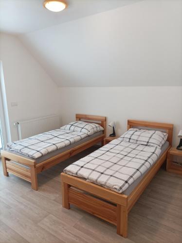 two twin beds sitting in a room with at Rodinné vinařství Guldanovi in Diváky
