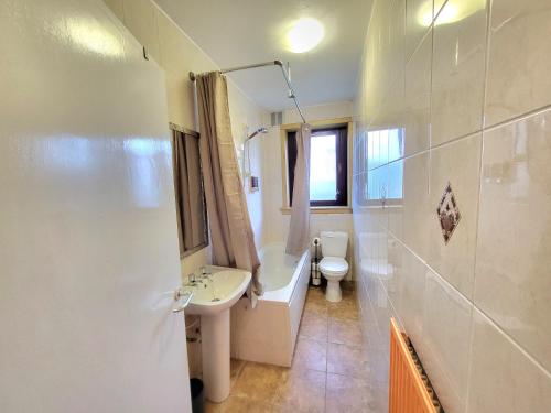 a bathroom with a sink and a tub and a toilet at 3 Bedroom Aprtmt at Sensational Stay Serviced Accommodation Aberdeen- Froghall Avenue in Aberdeen