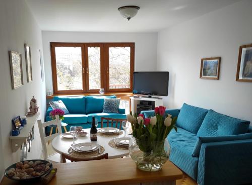 a living room with a blue couch and a table at JLS Apartament z parkingiem przy plaży in Gdańsk