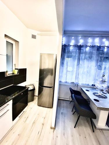 a kitchen with a stainless steel refrigerator and a table at Fakanalas Fogadó in Pásztó