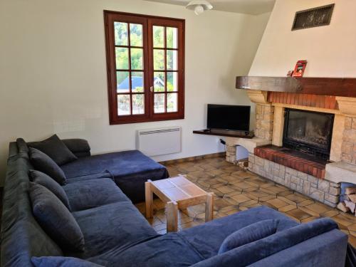 a living room with blue couches and a fireplace at Grande villa avec jardin privatif - Bagnères de Luchon in Juzet-de-Luchon