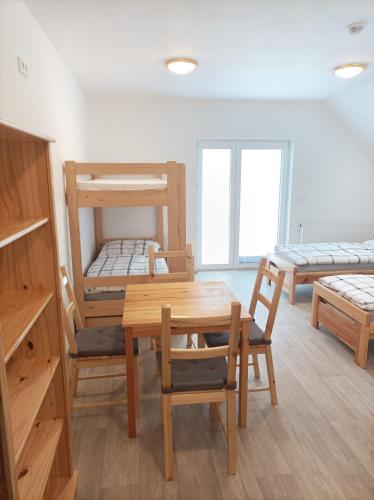 Zimmer mit einem Tisch, Stühlen und Etagenbetten in der Unterkunft Rodinné vinařství Guldanovi in Diváky