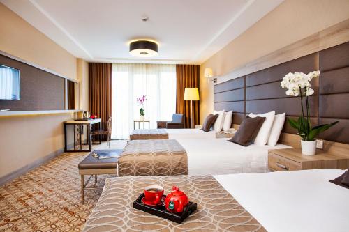a hotel room with two beds with red candles at Nidya Hotel Galataport in Istanbul