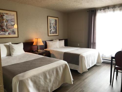 pokój hotelowy z 2 łóżkami i oknem w obiekcie Hôtel Mingan w mieście Sept-Îles