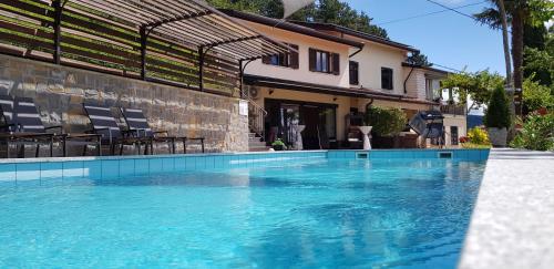 a swimming pool in front of a house at Valentina Guest House at Pintar Wine Estate in Kojsko