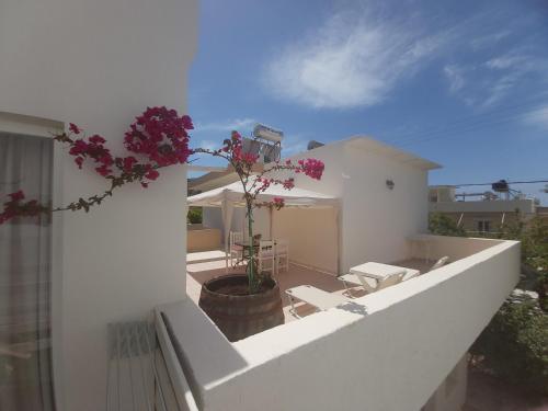 a balcony with flowers on a white building at Antonios 1 in Matala
