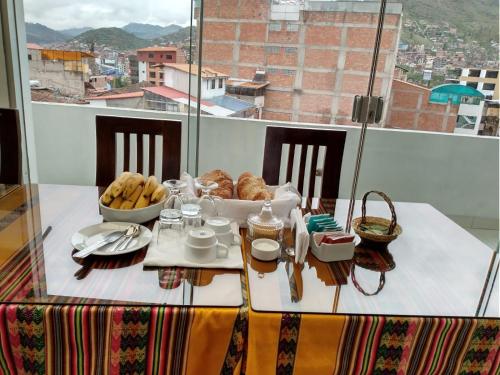 a table with a plate of food on it with a view at Alegrias Inn Hotel in Cusco