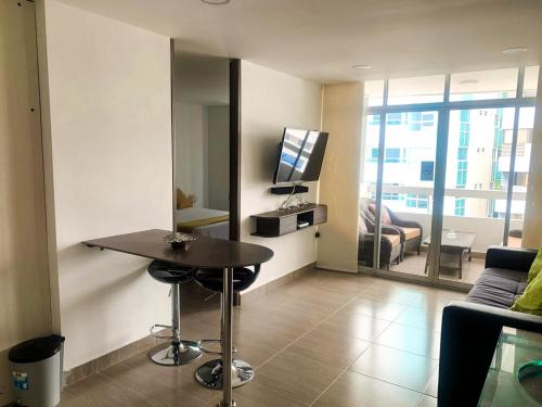 a living room with a table and a television in it at Polanco Residences Tocagua Cartagena - Colombia in Cartagena de Indias