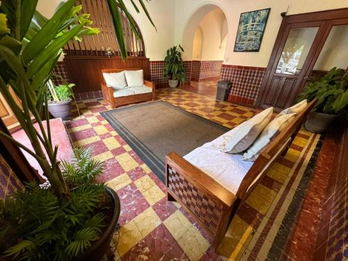 a room with a bed and a couch and a chair at Hotel Catedral in Cuernavaca