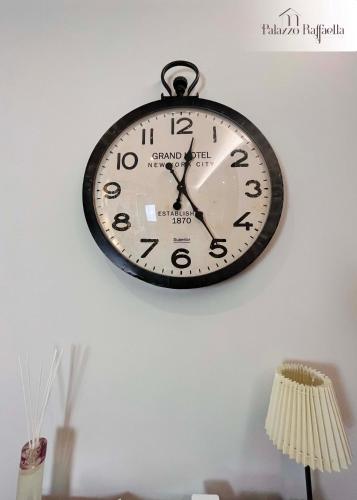 a clock is hanging on a wall at Palazzo Raffaella Casa vacanze in Castel SantʼElia