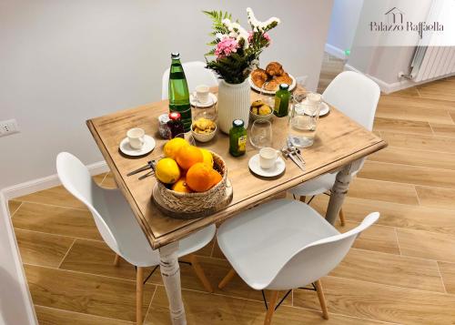 a table with a bowl of fruit and bottles of wine at Palazzo Raffaella Casa vacanze in Castel SantʼElia