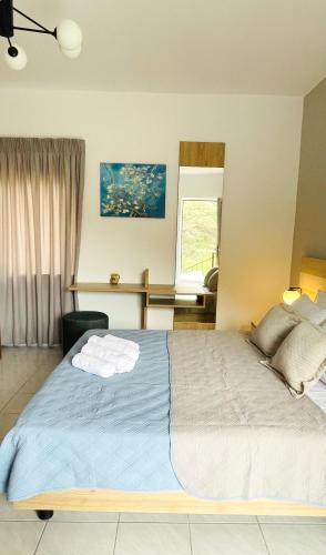 a bedroom with a large bed and a desk at Stelios Studios Sougia in Sougia