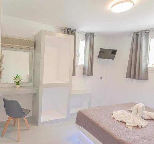 a bedroom with a bed and a chair and windows at Villa Katerina in Parikia