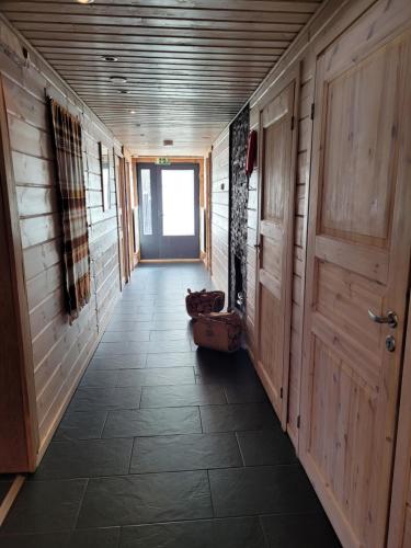 a hallway of a house with wooden walls and a door at Chalet Päämaja Rovaniemi in Rovaniemi
