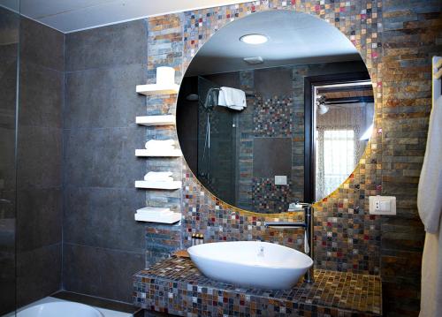 a bathroom with a sink and a mirror at Nassamat Boutique Hotel in Al Bārūk