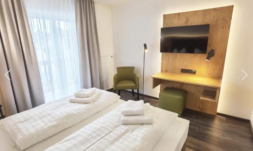 ein Hotelzimmer mit zwei Betten und einem Fernseher in der Unterkunft Waldschlößl in Bruckmühl