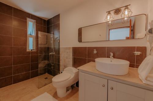a bathroom with a toilet and a sink and a mirror at Lumina at Jardines Punta Cana Village in Punta Cana