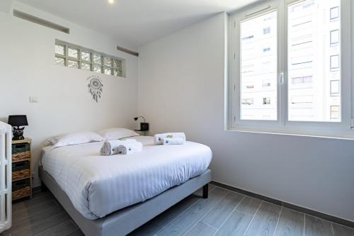 une chambre blanche avec un lit et une fenêtre dans l'établissement IMMOGROOM - Rénové - Terrasse - Clim - Calme - Carnot, à Cannes