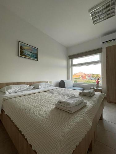 a bedroom with a large bed with two towels on it at Apartman Dunav in Kladovo