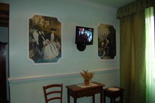 a room with a tv on a wall with a table and chairs at Sul Bacino in Massa Lombarda