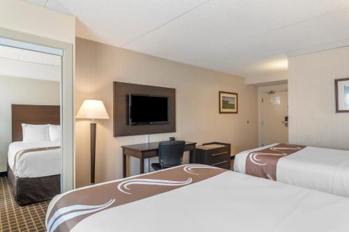 a hotel room with two beds and a television at Quality Inn & Suites Garden of the Gulf in Summerside