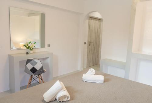 a bathroom with two towels on the floor and a mirror at Villa Katerina in Parikia