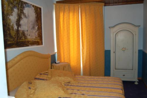 a bedroom with a bed and a window with orange curtains at Sul Bacino in Massa Lombarda