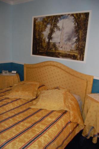 a bed in a bedroom with a painting on the wall at Sul Bacino in Massa Lombarda