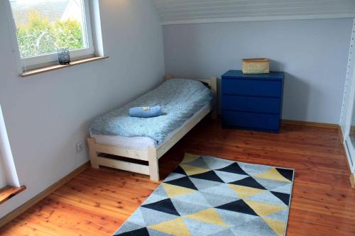 um pequeno quarto com uma cama e uma cómoda azul em Dom Wakacyjny Sarbsk Pomerania em Sarbsk