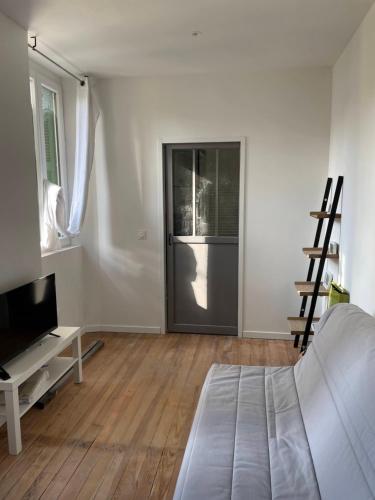 - une chambre avec un lit, une télévision et une porte dans l'établissement Charmant Studio proche Centre Ville et Gare, à Lourdes