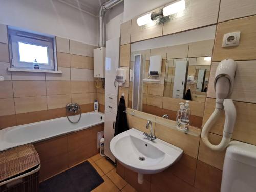 W łazience znajduje się umywalka i wanna. w obiekcie Smart Business Apartman w Miszkolcu