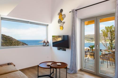 sala de estar con vistas al océano en Sunset Coast House - STONE, en Vathi