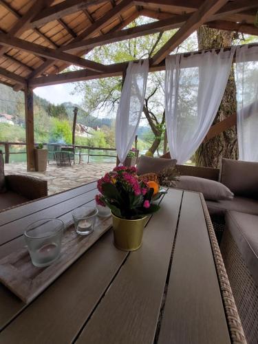 a wooden table with flowers on a patio at ATRIUM Holiday home in Bihać