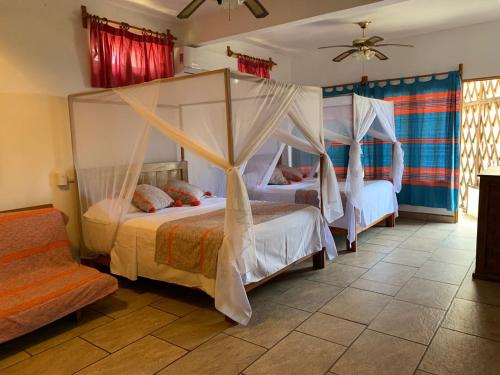 um quarto com 2 camas e redes mosquiteiras em Cabañas Telayú em Mazunte