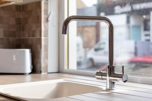 a sink in a kitchen with a window at Ayr Retreat - Donnini Apartments in Ayr