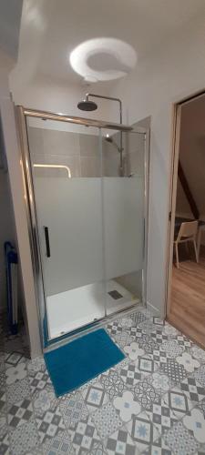 a glass wall in a room with a blue floor at Appartement dans maison de 1789 au centre de Vitré in Vitré