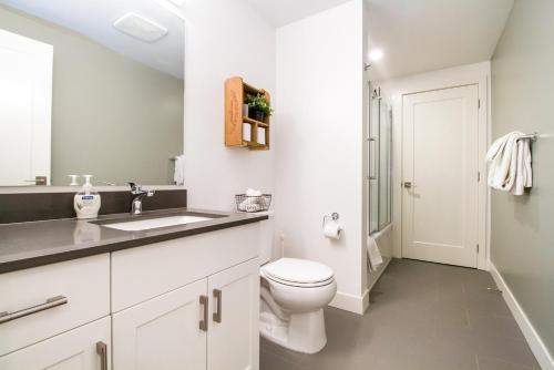 un bagno bianco con un water e un lavandino di Revelstoke Retreat by Revelstoke Vacations a Revelstoke