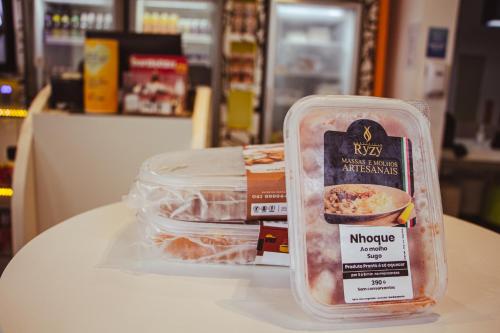 a plastic container of food sitting on a table at ibis budget Curitiba Aeroporto in São José dos Pinhais