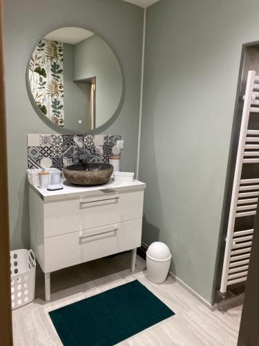 une salle de bain avec un lavabo et un miroir dans l'établissement Maison rez-de-chaussée 3 étoiles confortable, à Noyelles-sur-Mer