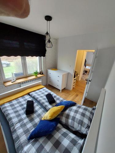 a bedroom with a bed with blue and yellow pillows at Domek przy plaży in Mikołajki