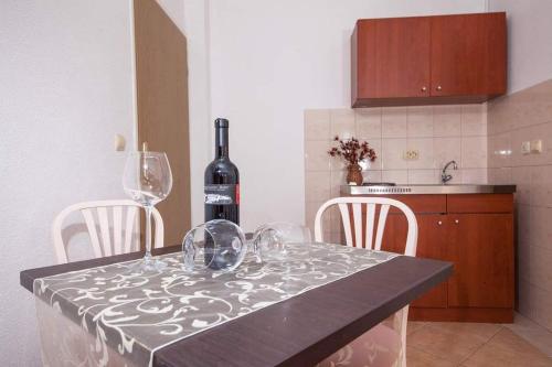 a kitchen with a table with wine glasses on it at Apartman Duje in Tučepi