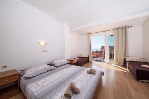 a bedroom with a large bed and a large window at Apartman Duje in Tučepi